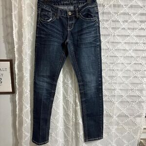 Dark wash skinny jeans with a‎ distressed look